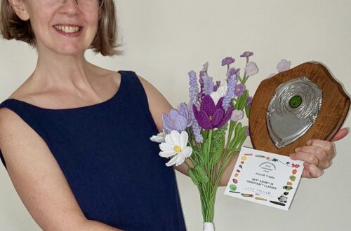 Photo of Lynn Archer in the local press holding 1st prize trophy