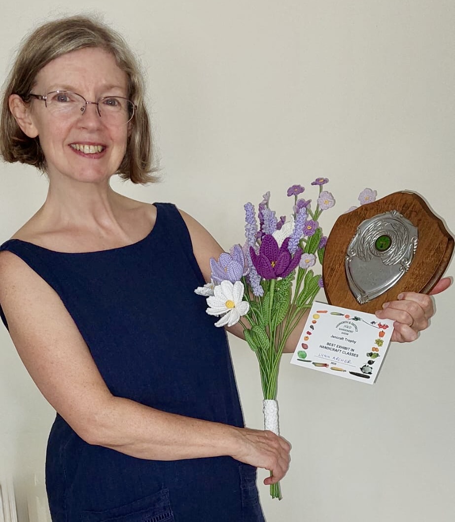 Photo of Lynn Archer in the local press holding 1st prize trophy